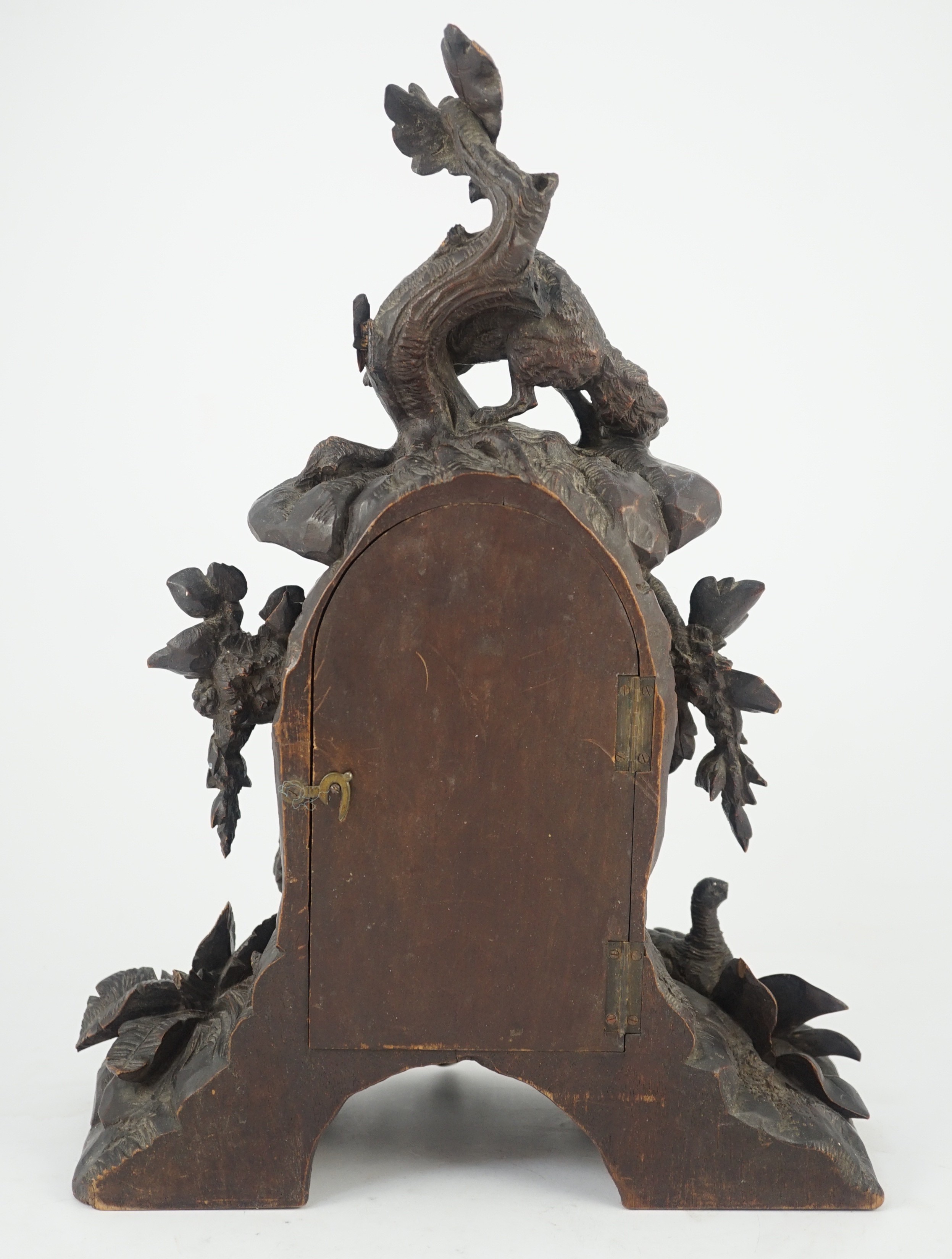 A 19th century Black Forest carved wood mantel timepiece, 30cm wide, 38cm high